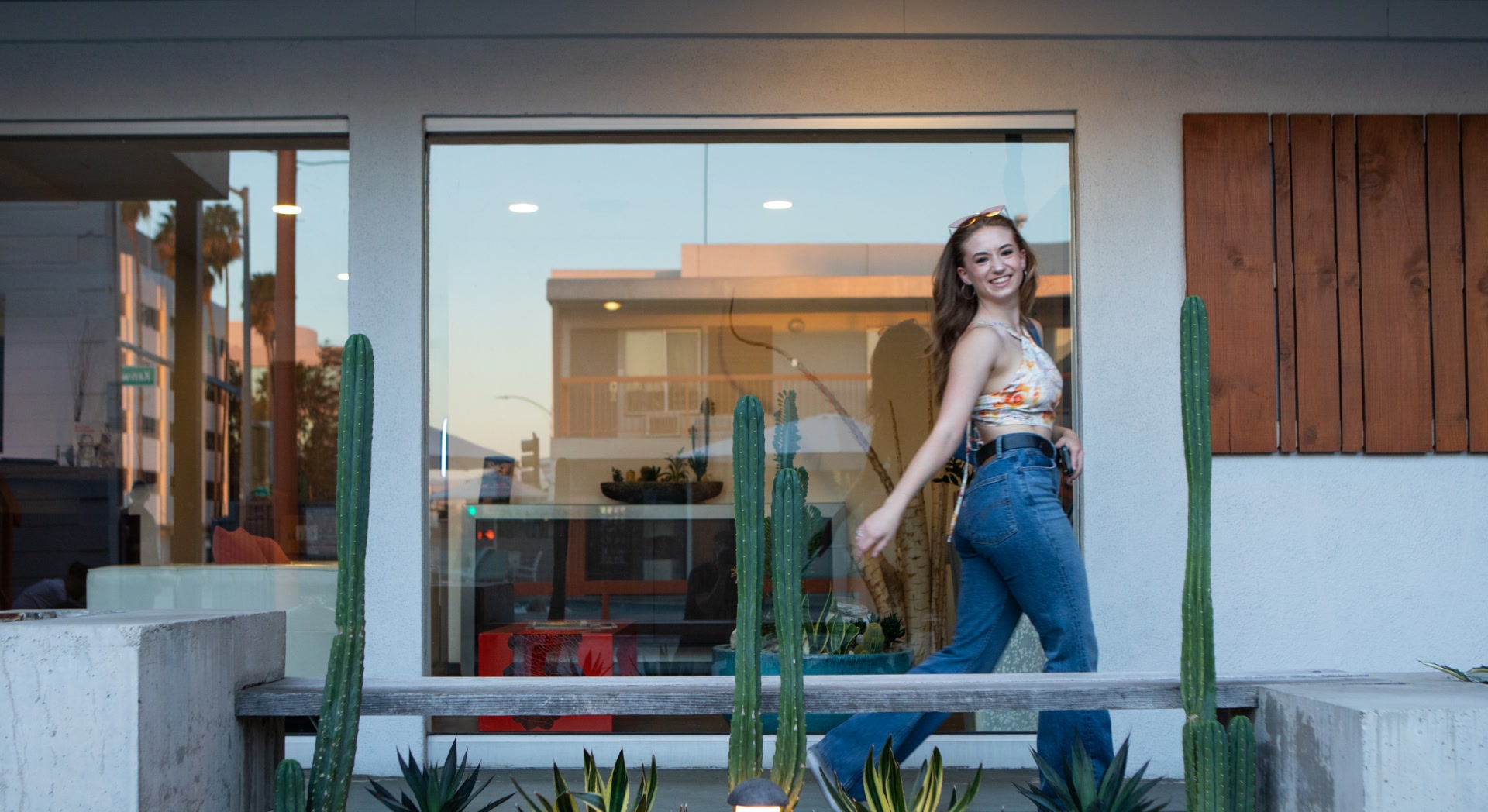 A woman steps out of a boutique on a sunny Burbank sidewalk