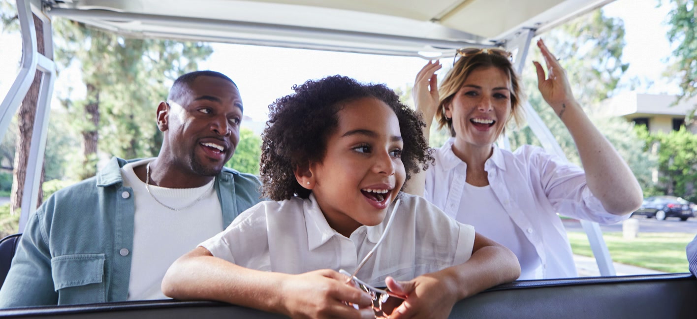 A family laughs together on a studio tour tram
