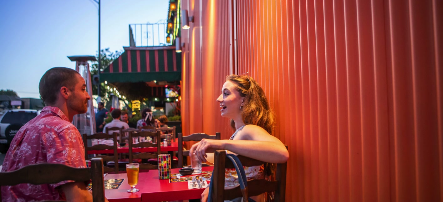 Two friends share drinks at a late-night restaurant