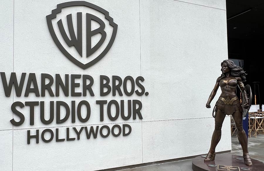 Wonder Woman statue stands next to the Warner Bros. Studio Tour Hollywood sign
