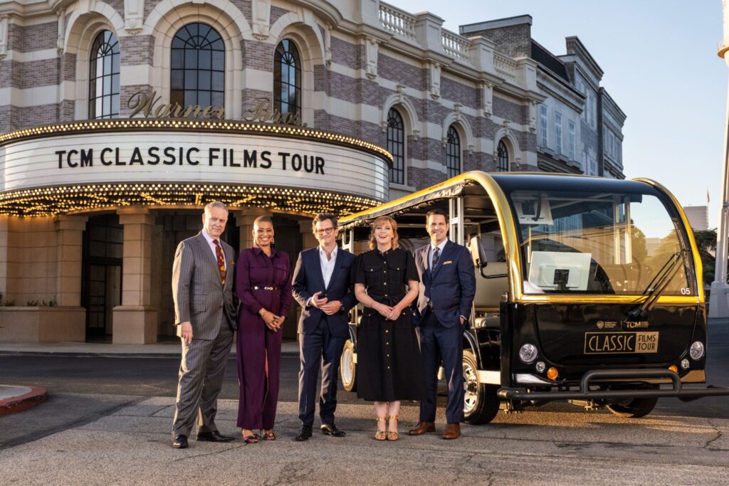 Warner Bros Studio tour Hollywood's TCM Classic Tour tram with a group of people standing in front of marquee