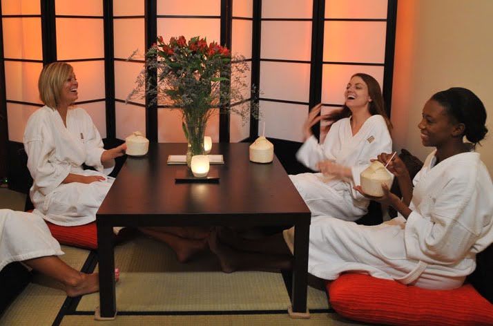 Women in white robes around a table at the spa
