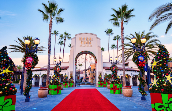 Universal Studios Hollywood front gate decorated for the holidays with red carpet, christmas lights, and giant red and green presents