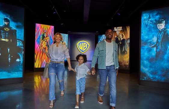 Family of three walk through Warner Bros studio tours hallway together