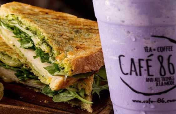 Cafe 86 Ube drink in front of panini