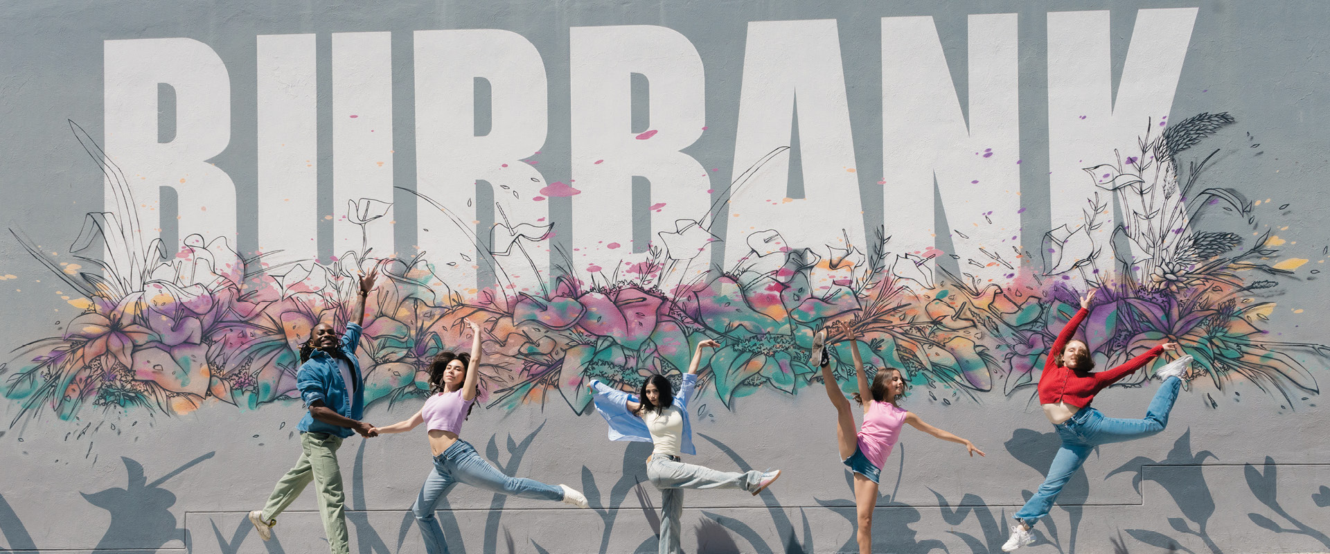 People posing in front of the "BURBANK" mural in downtown Burbank.