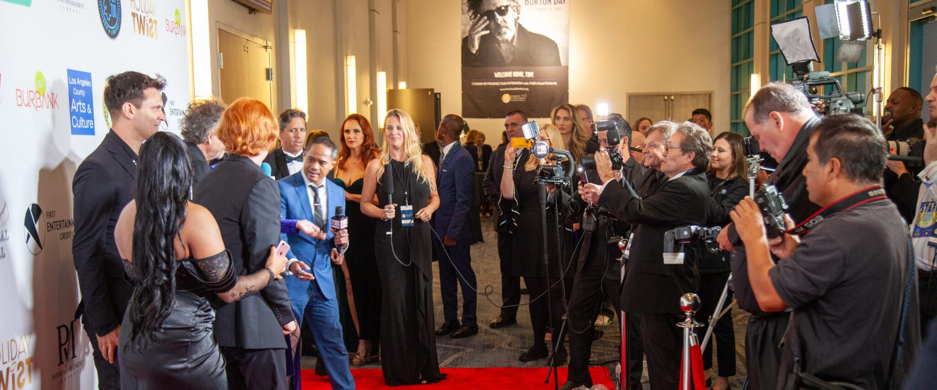 Photographers line the red carpet as guests pose in front of the Burbank International Film Festival step-and-repeat