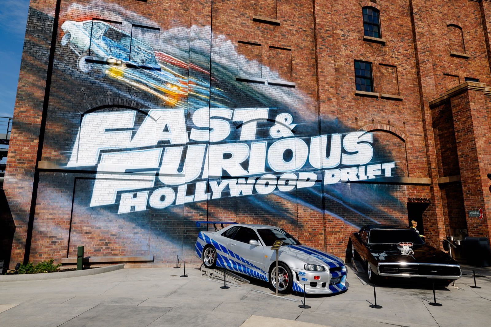 Fast & Furious: Hollywood Drift entrance mural with a Nissan Skyline GT-R and Dodge Charger on display at Universal Studios Hollywood