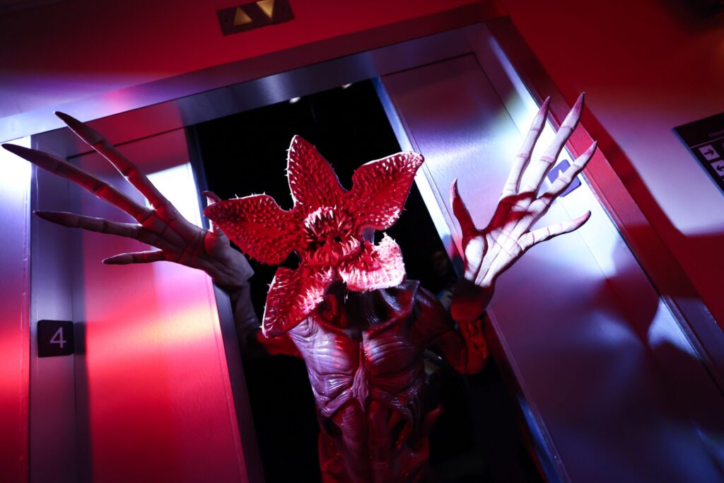 Guests scream as a Demogorgon lunges from the wall inside the Stranger Things haunted house at Halloween Horror Nights
