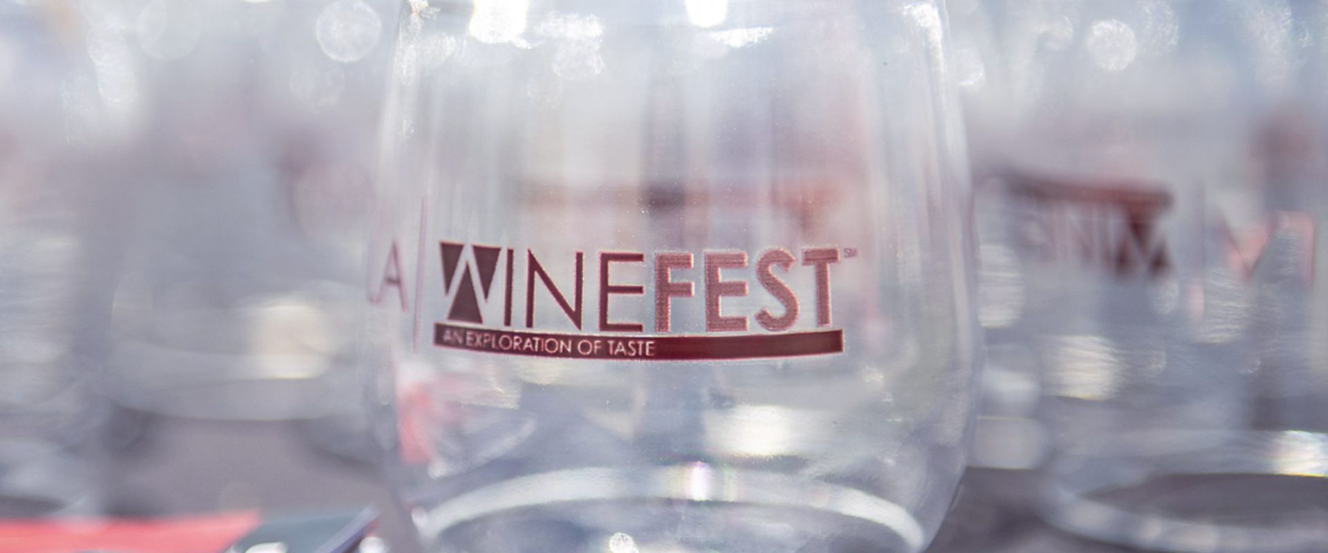 Rows of clear LA Wine Fest tasting glasses lined up on a table in the sun