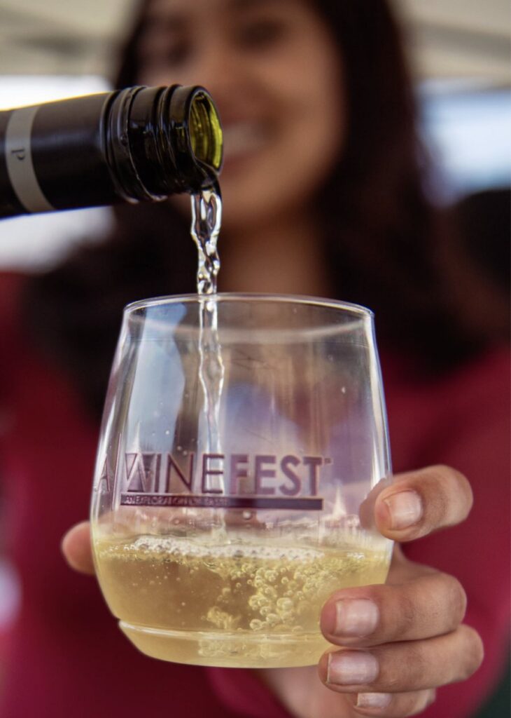 White wine being poured into an LA Wine Fest glass