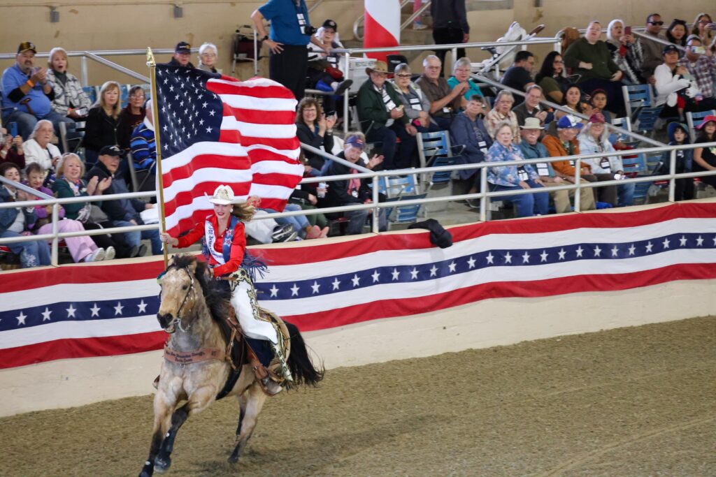 A rider carries an American flag around the Equestfest arena