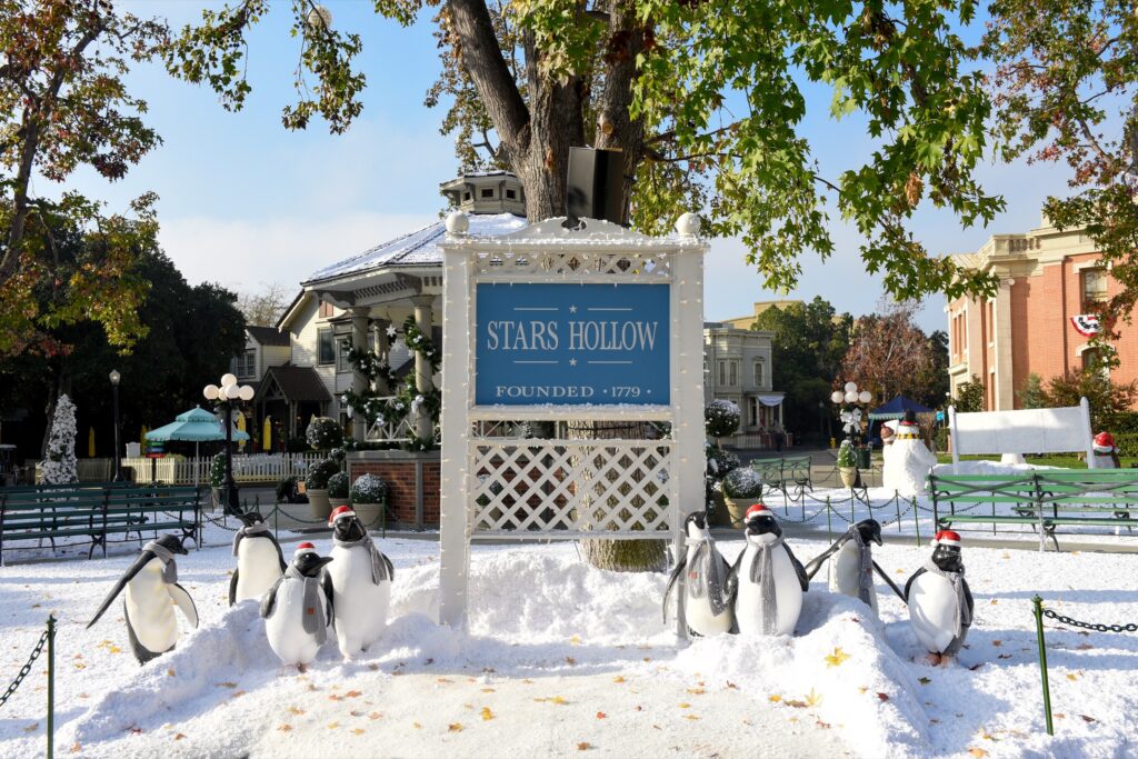 The Stars Hollow welcome sign surrounded by snow and penguin figures