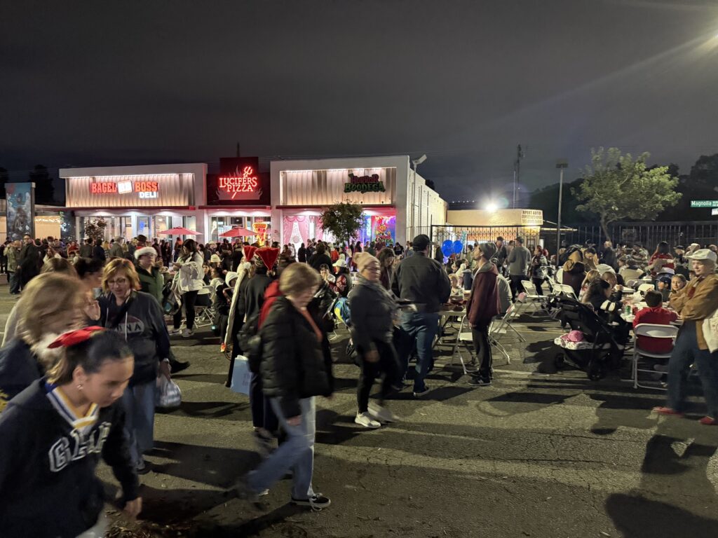 Crowds fill Magnolia Boulevard at night during Holiday in the Park