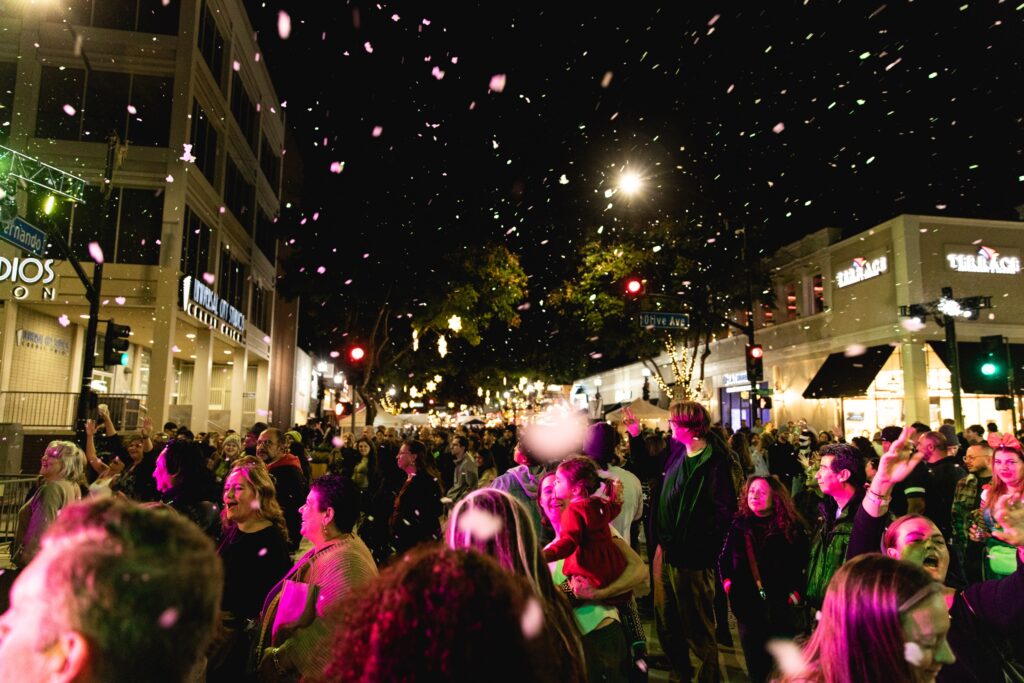Artificial snow falls over a crowded San Fernando Boulevard at night